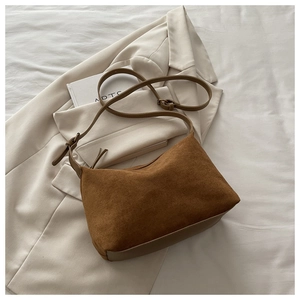 Detail view of the brown frosted suede texture and leather strap on a vintage tote bag