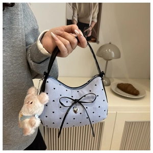 Détail du sac hobo à rayures bleues avec imprimé cœur, nœud et peluche lapin rose