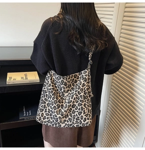 Detail of leopard print canvas tote bag featuring a black FASHION label on the side