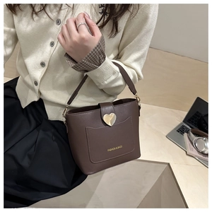 Gros plan du sac seau marron foncé avec boucle cœur et texture cuir grainé