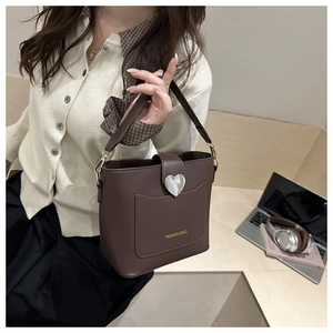 Détail du sac seau marron avec grand fermoir cœur argenté et texture en cuir grainé