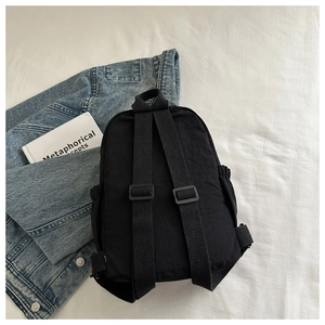 Detail view of the backpack back showing adjustable reinforced straps and top handle