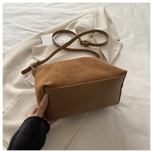 Detail of vintage brown tote bag with matte suede texture and smooth leather contrast