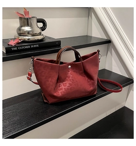 Detail of burgundy leopard jacquard tote with brown handles and silver magnetic clasp