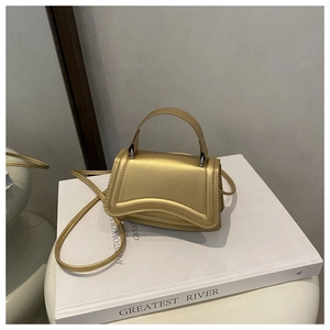 Detailed close-up of champagne gold mini square bag with premium metallic finish