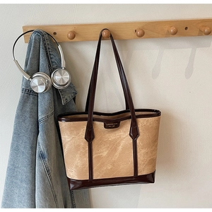 Détail du cabas minimaliste avec finition texture marbre et plaque logo en cuir
