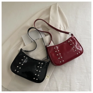 Black and wine red patent leather shoulder bags with silver rivet studs on suit fabric