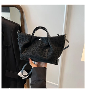 Detail of black leopard print tote bag with plush texture and silver snap button closure
