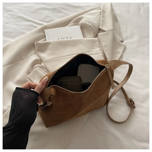 Detail view of the spacious interior of a dark brown suede crossbody underarm bag