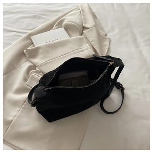 Detail view of the spacious black canvas bag interior with a golden metal zipper closure