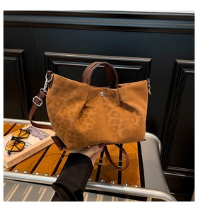 Close-up of leopard print tote bag with brown leather handles and silver magnetic clasp