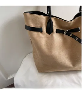 Detail der khakifarbene Veloursleder-Tasche mit schwarzem Lederriemen und Metallschnalle