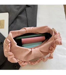 Interno della borsa a pieghe rosa che mostra lo spazio per telefono e portafoglio