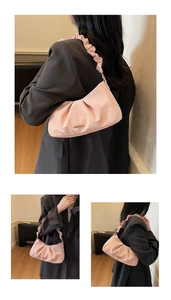 Detail view of pink pleated shoulder bag with ruffles and metallic brand logo