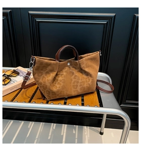 Detail of leopard print tote bag with leather handles and silver magnetic snap closure