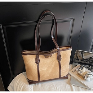 Détail du sac cabas vintage en daim avec poignées en cuir marron et boucle dorée