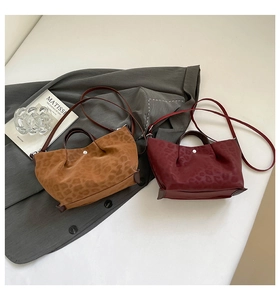 Detail of leopard print tote bags in brown and burgundy with soft faux suede texture