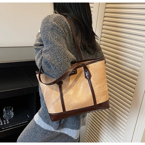 Grand sac cabas en toile avec garniture en cuir marron porté par un mannequin