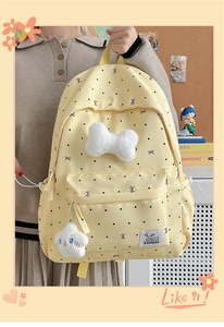 Polka dot backpack with bow decoration and cute cloud keychain in a study scene