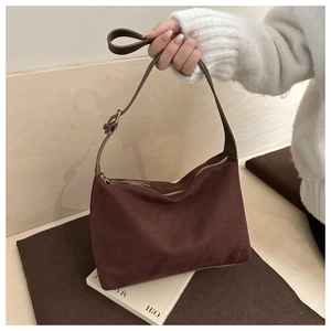 Close-up of retro brown suede hobo bag with adjustable leather strap and metal buckle
