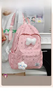 Detailed side view of pink polka dot backpack with plush bow and star pendant