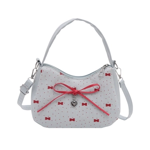 Sac à main bleu clair à pois rouges avec nœud décoratif et pendentif cœur argenté