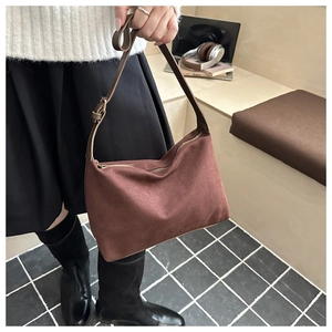 Detail of reddish-brown vintage canvas shoulder bag with adjustable brown leather strap