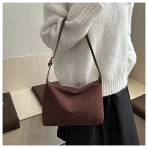 Detail of vintage brown suede tote bag featuring a metallic buckle on the shoulder strap