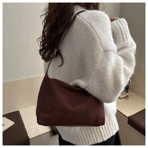 Brown minimalist nylon shoulder bag worn over a white chunky knit sweater for fall