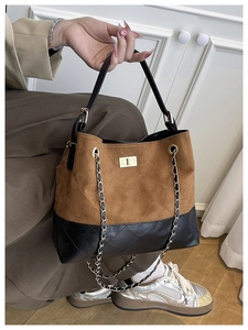 Close-up of quilted bucket bag with gold clasp and brown suede black leather contrast