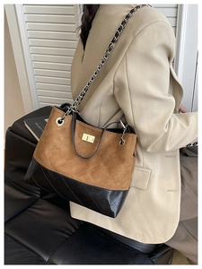 Detail of quilted suede shoulder bag with gold chain strap and metal turn-lock closure