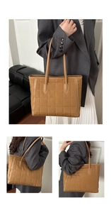 Detail of brown quilted tote bag showing square stitching and slim shoulder straps