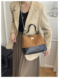 Detail of contrast stitching and gold twist lock on a vintage chain shoulder bag