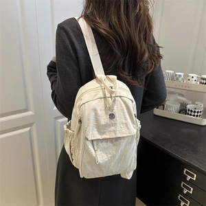 Chic cream nylon backpack with spacious compartments shown on model from back view