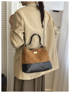 Détail du sac bandoulière vintage montrant la texture matelassée et la chaîne sur modèle