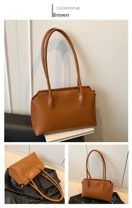 Detail view of large brown faux leather tote bag with wavy side edges and shoulder straps