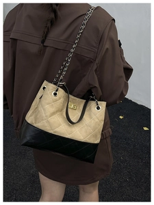 Détails du sac seau bicolore avec velours matelassé et bandoulière en chaîne dorée