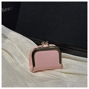 Detailed view of pink pebble grain leather mini clasp purse on white silk fabric