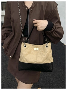 Detail of quilted two-tone hobo bag with gold metal twist lock and chain strap