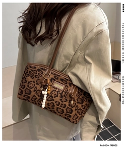 Detail of leopard print tote bag featuring wooden bead charms and vintage brown leather trim