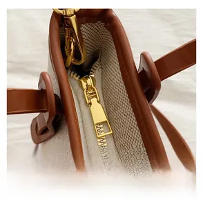 Detail view of the smooth golden zipper and premium canvas stitching on the bucket bag