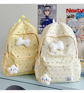 Detailed view of polka dot backpack featuring a plush white bow and star charm decoration