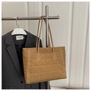 Detail shot of the brown quilted tote bag showing its lightweight fabric and fine stitching