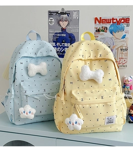 Detail of light blue and yellow polka dot backpacks with plush bows and star charms