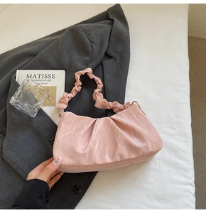 Detailed view of pink pleated handbag with soft PU texture in a stylish modern aesthetic
