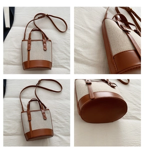 Detail view of two-tone canvas bucket bag with brown leather trim and shoulder strap