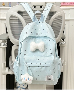 Detail of light blue polka dot backpack featuring large plush bow and soft star charm