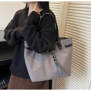 Detail view of large grey suede tote bag with black strap and buckle for daily commute