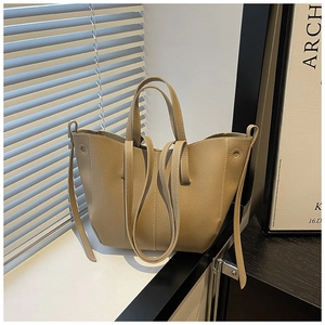Detail of light khaki pebble leather bucket bag with vertical stitching and top handles