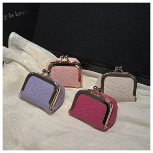Detailed view of mini kiss-lock coin purses in four colors on elegant silk fabric
